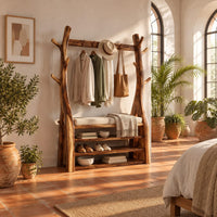 Tree trunk wardrobe with a top beam and bench seat above open shelves in a bright bedroom with arched windows and plants