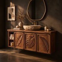Bathroom vanity cabinet with three tropical leaf carved doors and an open shelf, three-quarter view showing the grain