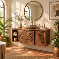 Bathroom vanity cabinet with three tropical leaf carved doors and an open shelf in a bright bathroom with arched windows and plants