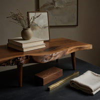 Corner detail of mid century TV console with a live edge top beside wood, brass and linen samples