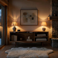 Mid century TV console with a live edge top in an evening room lit by two lamps