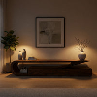 TV console with a curling hook top over drawers in an evening room lit by two lamps