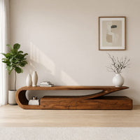 TV console with a curling hook top over drawers in a sunlit room with large windows and plants