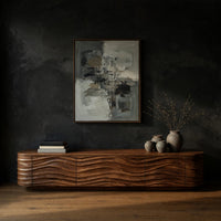 Low TV stand with wave carved door fronts in a dark studio against a charcoal wall