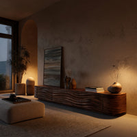 Low TV stand with wave carved door fronts in an evening room lit by two lamps