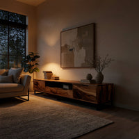 TV stand with figured wood doors on a black metal frame in an evening room lit by two lamps