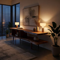 Split level live edge TV stand on tapered legs in an evening room lit by two lamps