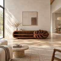 Low tv stand with two open shelves and a carved monstera leaf end in a bright open plan living room
