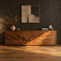 Low wooden tv stand with carved ocean wave and sun ray doors in a dark studio against a charcoal plaster wall