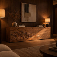 Low wooden tv stand with carved ocean wave and sun ray doors in an evening living room with walnut wall paneling