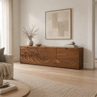 Low wooden tv stand with carved ocean wave and sun ray doors in a Scandinavian living room with white walls