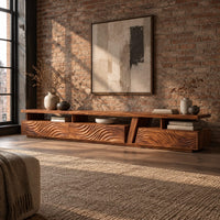 Long low tv stand with carved wave fronts and an open shelf above in an industrial loft living room with exposed brick