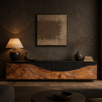 Low tv stand with carved flowing grain panels under a dark top band in a dark living room at golden hour
