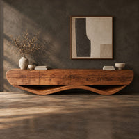 Corner detail of low tv stand with a thick four panel body on a wavy ribbon base beside wood, brass and linen samples