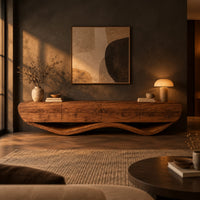 Low tv stand with a thick four panel body on a wavy ribbon base in a dark living room at golden hour