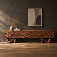 Tv stand with four wave carved panels on two twisting ribbon feet in a dark studio against a charcoal plaster wall