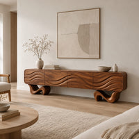 Tv stand with four wave carved panels on two twisting ribbon feet in a Scandinavian living room with white walls