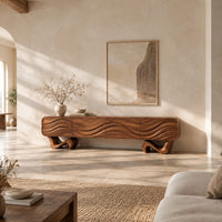 Tv stand with four wave carved panels on two twisting ribbon feet in a bright open plan living room