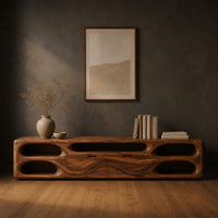 Long tv stand with pill shaped end niches and two center fronts in a dark studio against a charcoal plaster wall
