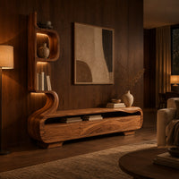 Low media console with a tall sculpted display tower at one end in an evening living room with walnut wall paneling