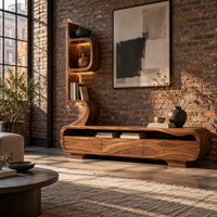 Low media console with a tall sculpted display tower at one end in an industrial loft living room with exposed brick