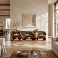 Low wooden tv stand with two rows of sculpted open cells in a bright open plan living room