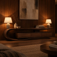 Tv stand with a sweeping loop end and low three panel cabinet in an evening living room with walnut wall paneling