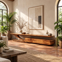 Tv stand with a sweeping plank top and a low two panel cabinet block in a bright living room with arched windows and plants