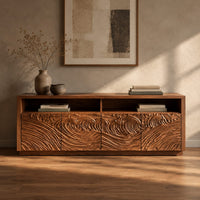 Corner detail of tv stand with four swirl carved door fronts and two open top bays beside wood, brass and linen samples