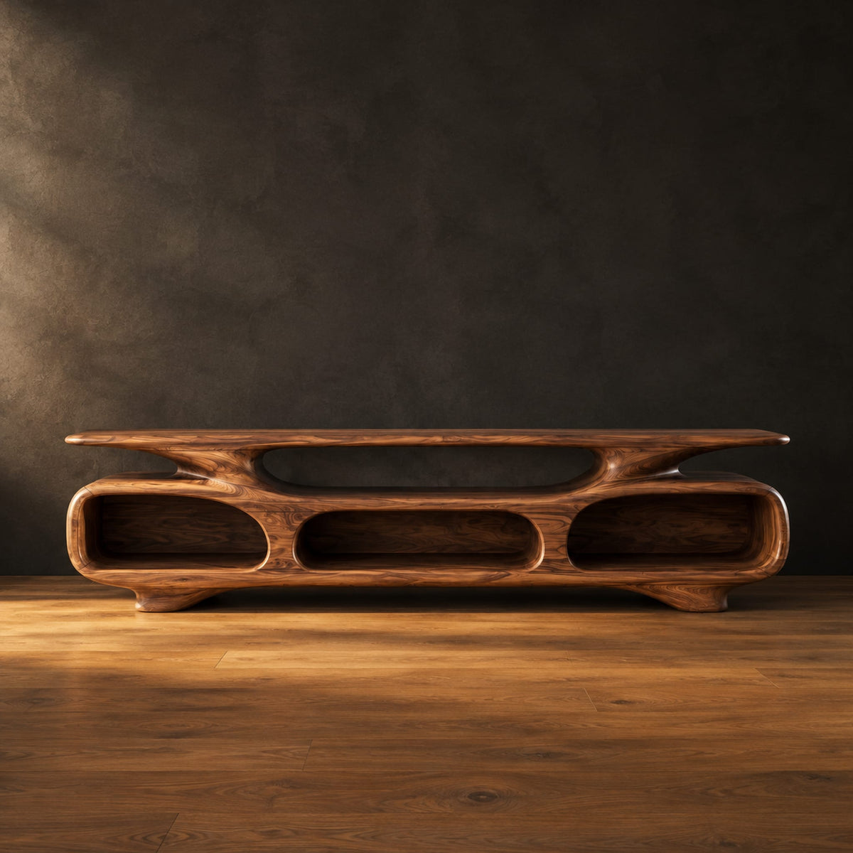 Low tv stand with three open oval cubbies under a sculpted slab top in a dark studio against a charcoal plaster wall
