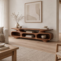 Low tv stand with three open oval cubbies under a sculpted slab top in a Scandinavian living room with white walls