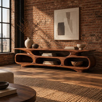 Low tv stand with three open oval cubbies under a sculpted slab top in an industrial loft living room with exposed brick