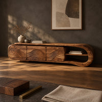 Corner detail of tv stand with three wave carved fronts and an open looped end shelf beside wood, brass and linen samples