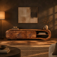 Tv stand with three wave carved fronts and an open looped end shelf in a dark living room at golden hour