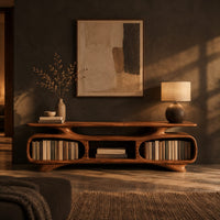 Low tv stand with two oval bays, a center shelf and sculpted feet in a dark living room at golden hour