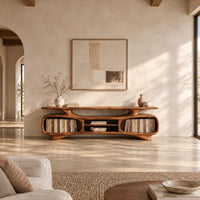 Low tv stand with two oval bays, a center shelf and sculpted feet in a bright open plan living room