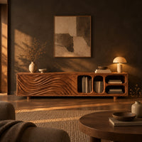 Low tv stand with wave carved fronts and open pill shaped cubbies in a dark living room at golden hour