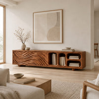 Low tv stand with wave carved fronts and open pill shaped cubbies in a Scandinavian living room with white walls