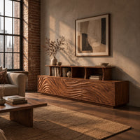 Tv stand with wave carved front panels and a raised open display shelf in an industrial loft living room with exposed brick