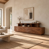 Tv stand with wave carved front panels and a raised open display shelf in a bright open plan living room