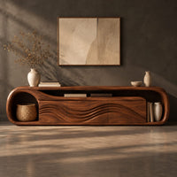 Corner detail of capsule shaped tv stand with wave relief fronts and an open end niche beside wood, brass and linen samples