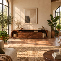 Capsule shaped tv stand with wave relief fronts and an open end niche in a bright living room with arched windows and plants