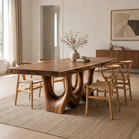 Dining table with a natural edge slab top and two sculpted arch legs in a Scandinavian dining room with white walls