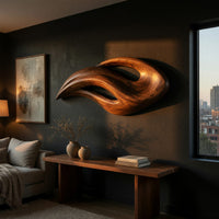 Twin crescent carved wood wall sculpture above a low console in an evening living room