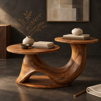 Corner detail of coffee table with two disc tops at different heights on a swooping base beside wood, brass and linen samples