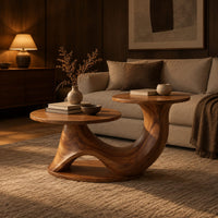 Coffee table with two disc tops at different heights on a swooping base in an evening living room with walnut wall paneling