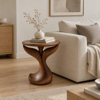 Pedestal side table with a round top, twin fins and a curled foot in a Scandinavian living room with white walls