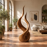 Twin flame wood sculpture with two tall tips and a smooth teardrop base in a bright living room with arched windows and plants