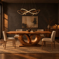 Rectangular dining table on a base of two large open loops in a dark dining room at golden hour