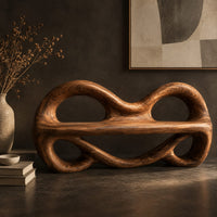Corner detail of wood bench with two looped openings above a flat plank seat beside wood, brass and linen samples